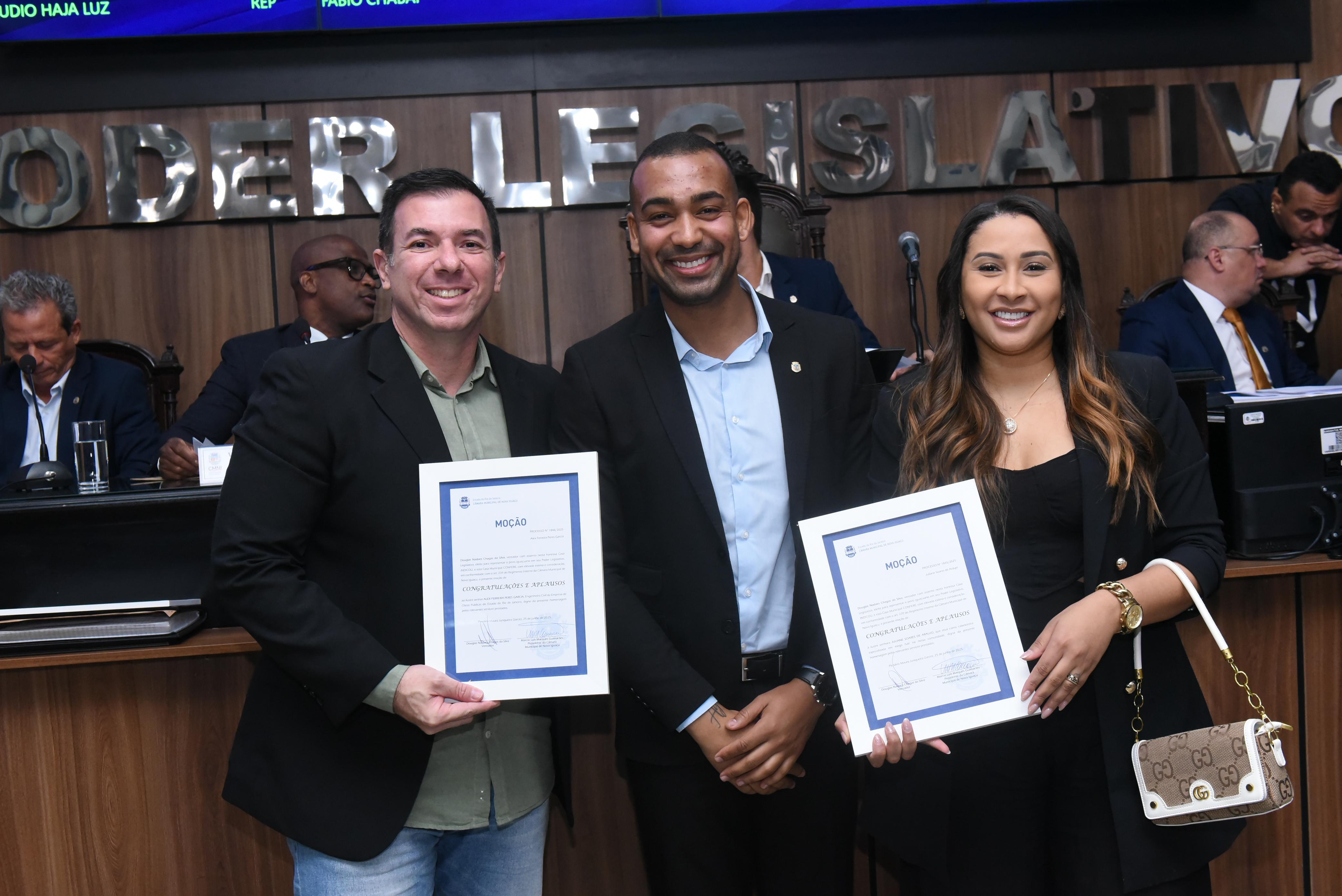 O engenheiro civil Alex Ferreira e a cabelereira Juliane Soares recebem suas moções assinadas pelo vereador Douglas Nadaes