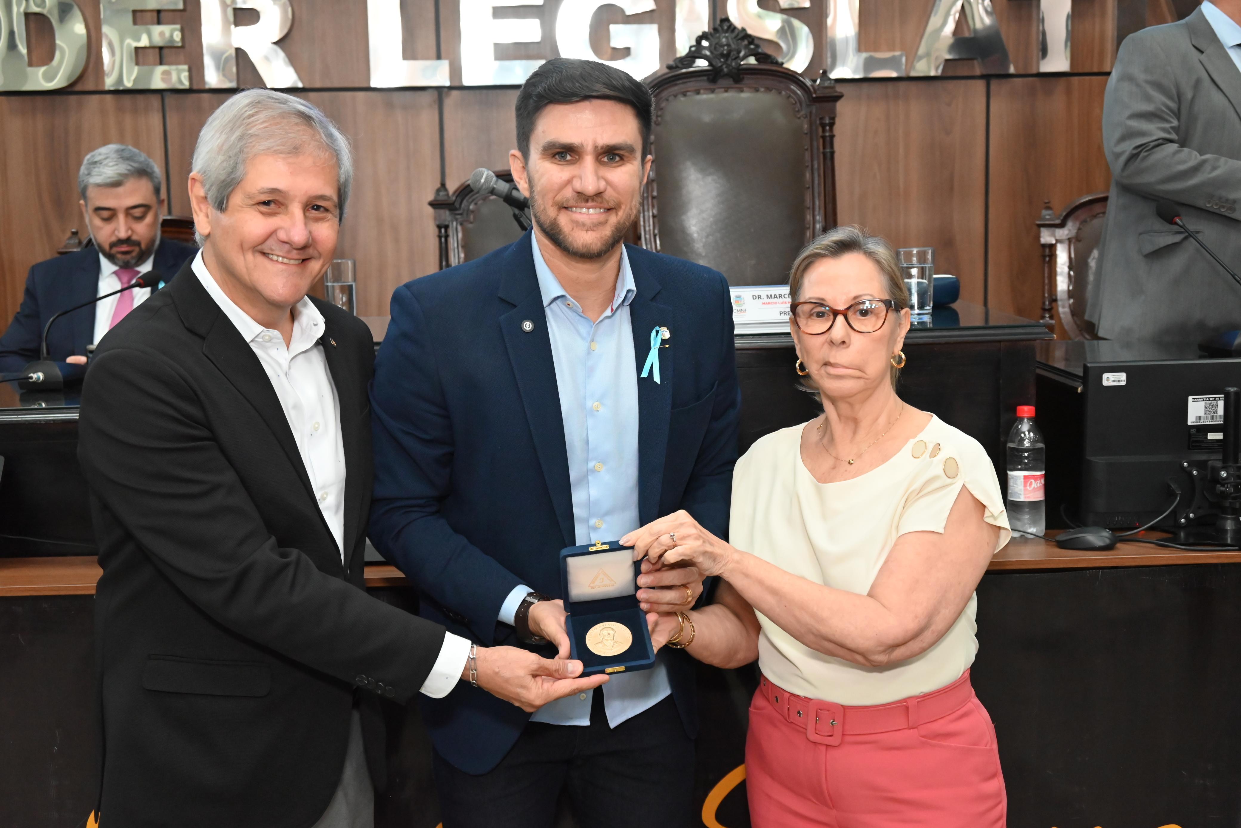 O presidente da Câmara, no centro, é homenageado com a Medalha Sylvio Coelho entregue por Mário Lopes e pela diretora da empresa Granfino, Silvia Coelho
